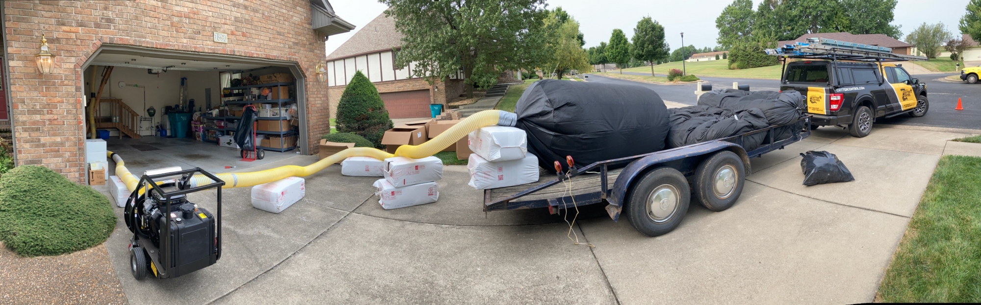 Garage with Bags of Attic Insulation Equipment and Critter Control Truck